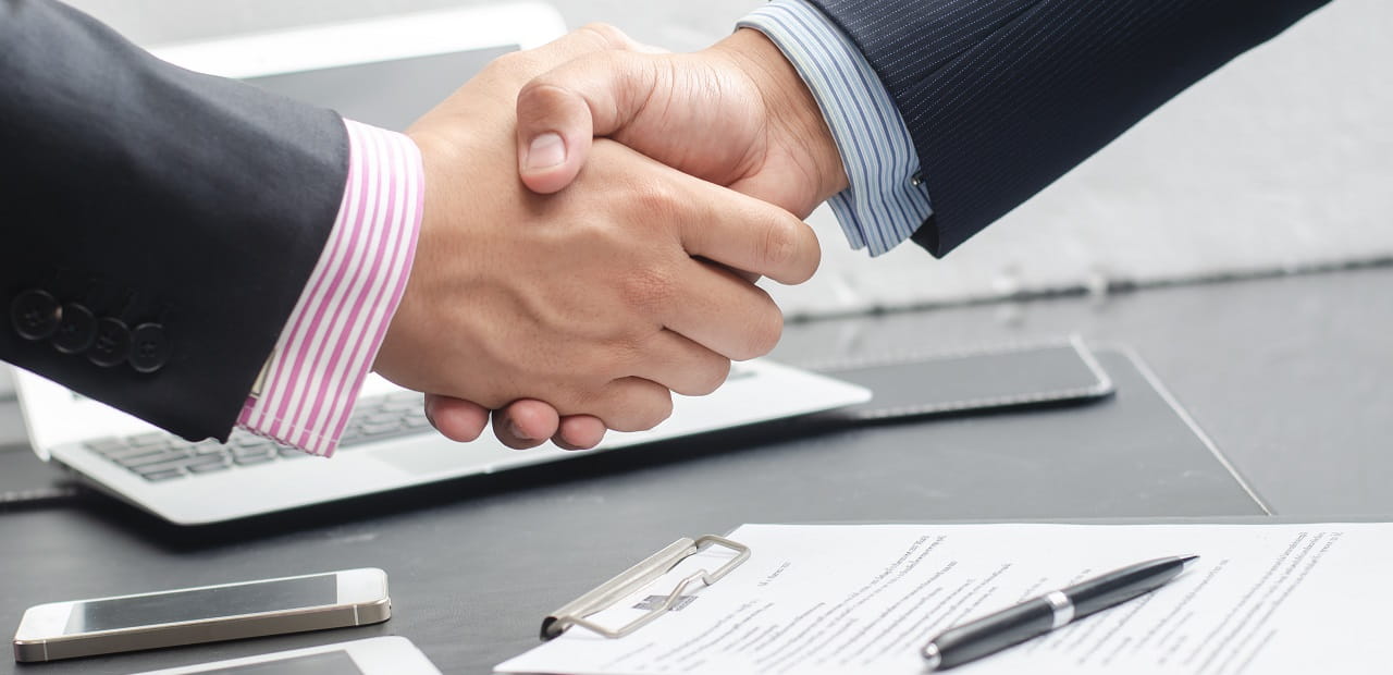 Handshake between two professionals in business attire.